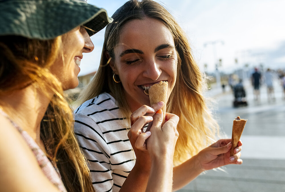 Two young women eating ice cream and enjoying the Summer Feelings.
