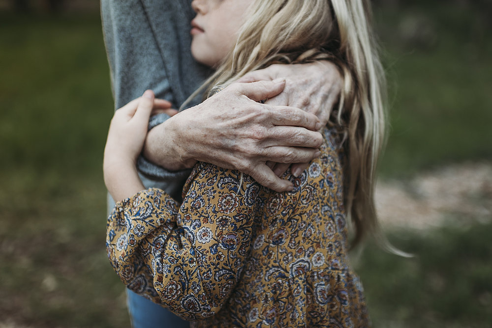 Old woman holding girl in her arms.