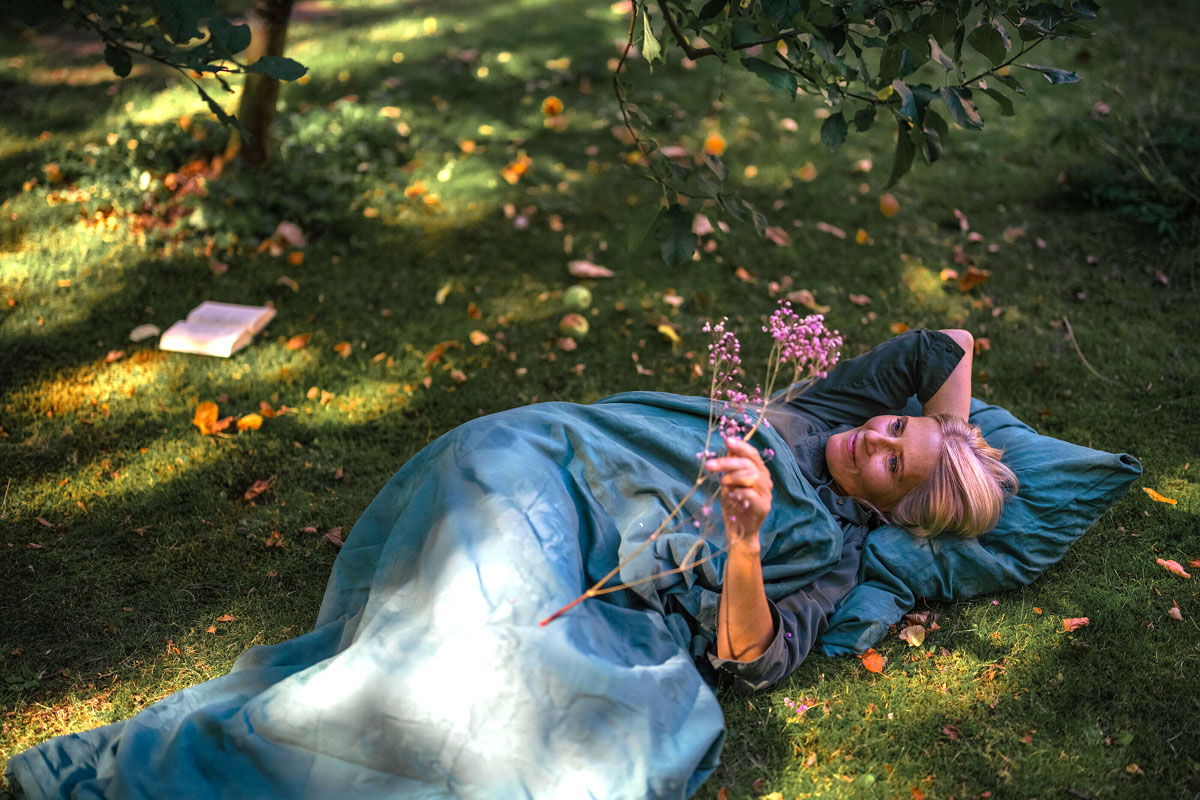 Woman lying in the garden enjoying her selfcare moment.
