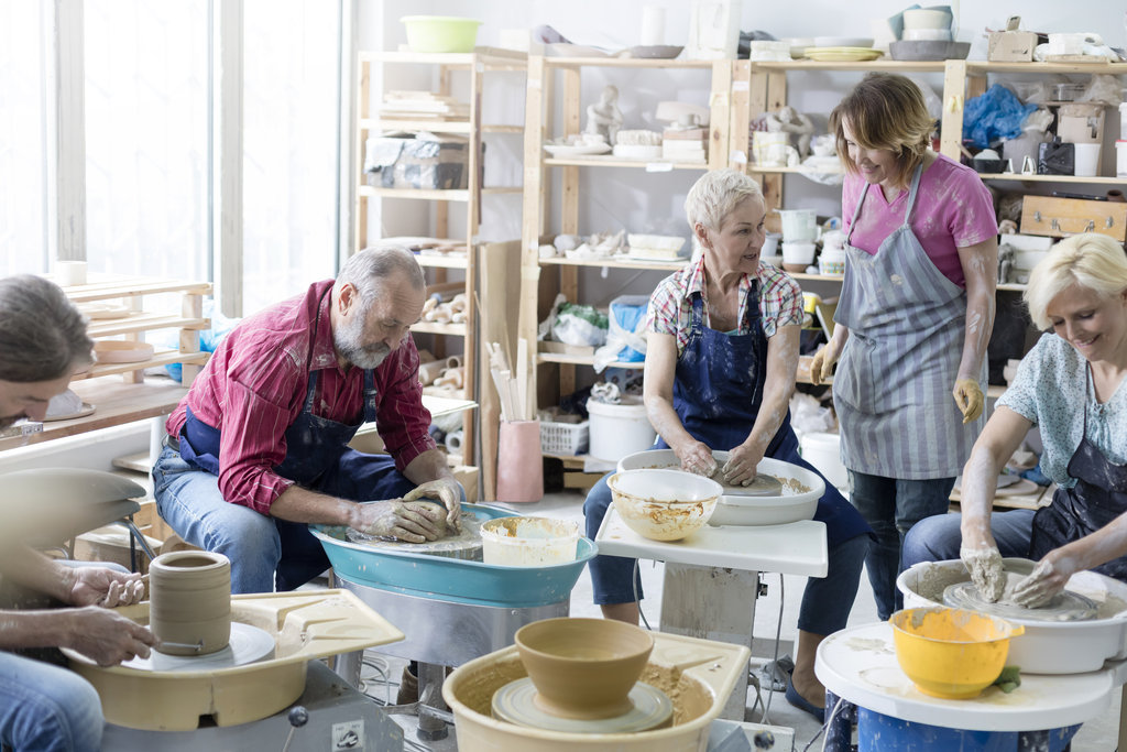 a group of beginners learn to make pottery